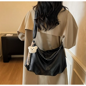 Détail du sac hobo en cuir PU noir avec chaîne en métal et breloque ours peluche