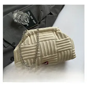 Détail du sac bandoulière beige matelassé avec texture tissée et chaîne en argent