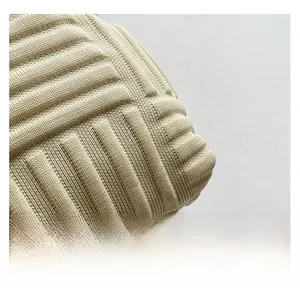 Primer plano del tejido de punto crema con textura plisada vertical del bolso de concha