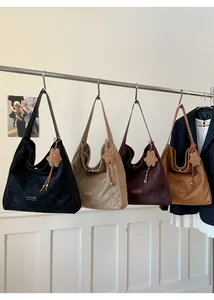 Detail of vintage suede tote bags in various colors hanging with plush charms