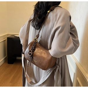 Detail view of a vintage dark brown hobo bag with knotted strap and gold foil branding