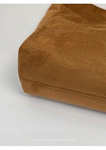 Detailed close-up of brown suede bucket bag featuring premium double stitching craftsmanship
