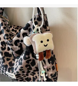 Cute toast plush bag charm with a smiling face on a leopard print tote bag