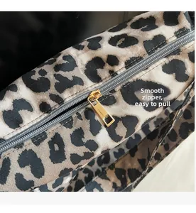 Close-up of smooth gold metal zipper on leopard print canvas bag detailing quality