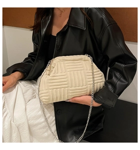 Detalle del bolso nube crema con textura tejida en 3D y correa de cadena plateada