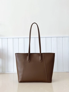 Detailed view of dark brown tote bag with V-shaped stitching and matte leather texture