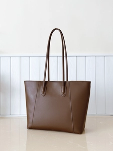 Detail view of large dark brown tote bag in matte leather with fine natural texture