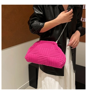 Détail du sac fuchsia avec texture plissée et fine bandoulière en chaîne argentée