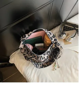 Spacious interior of leopard print tote bag holding a tablet, bottle, and daily items