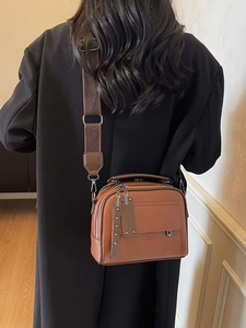 Retro brown lychee textured crossbody bag with a wide strap shown on a model