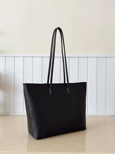 Detailed view of the black tote bag showing smooth leather texture and stitching detail