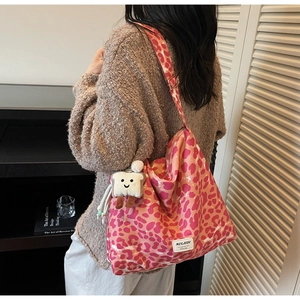 Detail of pink leopard print tote bag with a cute bread plush charm and MULAIDI label