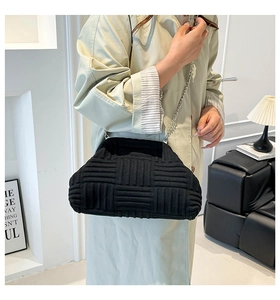 Detalle del bolso de nube trenzado negro con cadena plateada y textura plisada