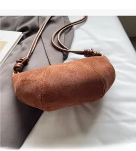 Dettaglio della borsa a mezzaluna in camoscio opaco caramello con tracolla in corda annodata
