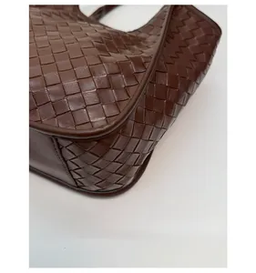 Detailed close-up of deep brown woven leather bag featuring reinforced bottom corners