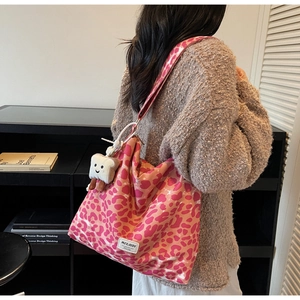 Close-up of pink leopard print tote bag with wide strap and plush bread charm detail