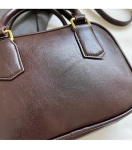 Detailed shot of dark brown leather texture and premium gold metal buckle on a handbag