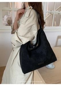 Detail of minimalist black suede hobo bag with a sophisticated vintage matte finish