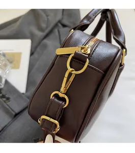 Detail view of dark brown PU handbag featuring gold metal hardware and side construction
