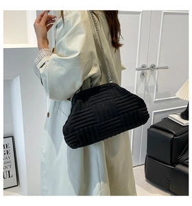 Detalle de bolso nube negro con textura trenzada y cadena plateada en modelo