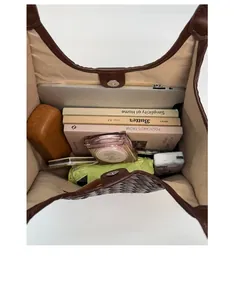 Spacious interior of dark brown woven tote bag with zip pocket and daily essentials