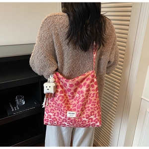 Detailed texture of pink leopard print canvas tote bag with a cute toast plush charm