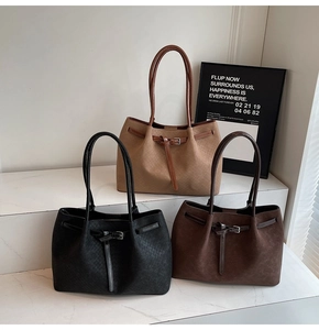Three minimalist woven suede tote bags in black, dark brown and khaki on white steps