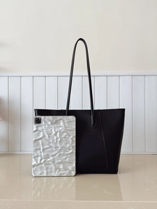 Detail view of large black tote bag showing spacious capacity for tablets and essentials
