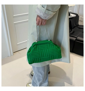 Detail of green woven shell bag with pleated closure and silver metal chain strap