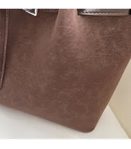 Detail of soft dark brown tote bag showing textured woven material and smooth matte finish