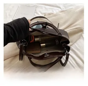 Detail view of spacious brown PU leather bag interior with magnetic closure and gray lining