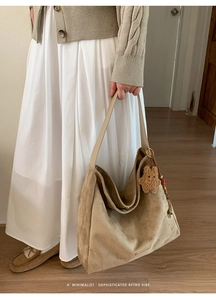Detail of khaki suede tote bag featuring a plush star charm and colorful beads decoration