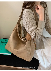 Chic brown suede tote bag with cute bear charm held by model in casual knit outfit