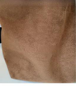 Close-up of premium brown suede tote bag fabric with refined matte texture and soft touch