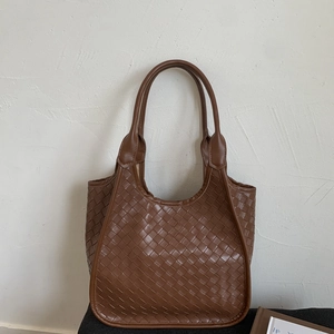 Detailed view of the brown woven leather tote bag featuring Intrecciato texture and design