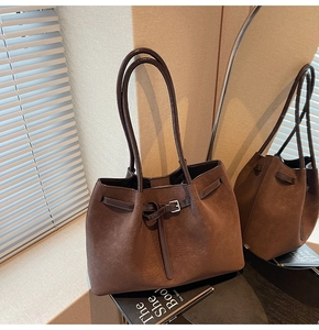 Detailed macro view of dark brown matte PU leather texture and decorative strap buckle