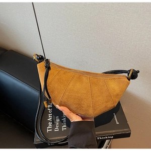 Dettaglio della borsa a mezzaluna in camoscio opaco con cuciture a pieghe e fibbia oro