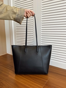 Detail of minimalist black matte PU leather tote bag with reinforced shoulder straps