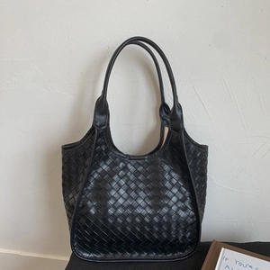 Detailed view of the black woven texture and thick cross-weave pattern on the tote bag