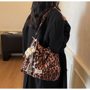 Detailed back view of a leopard print tote bag with a plush toast charm on the shoulder