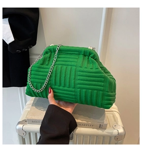Close-up of emerald green knit shell bag with geometric texture and silver chain