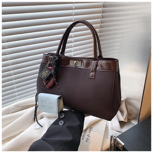 Detail of vintage matte brown tote bag with silver rotary lock and stylish mini charms