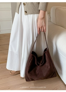 Detail of minimalist dark brown suede tote bag styled with a retro casual autumn outfit