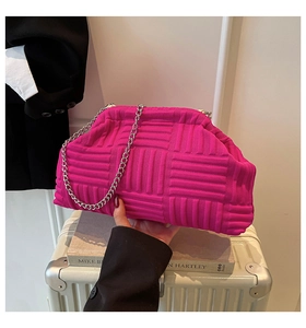 Detail of hot pink woven cloud bag featuring shell pleats and silver chain strap