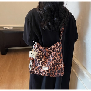 Detail view of leopard print shoulder bag with a cute plush toast charm accessory