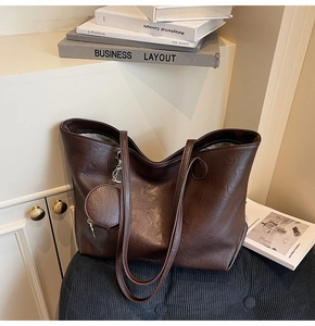 Detail of dark brown tote bag with vintage leather texture and matching coin purse