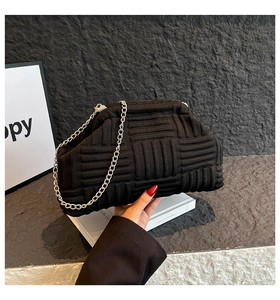 Détail du sac nuage noir montrant la texture tissée et la bandoulière chaîne argent