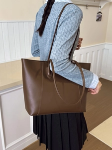 Large dark brown leather tote bag for women showing a minimalist shoulder bag style