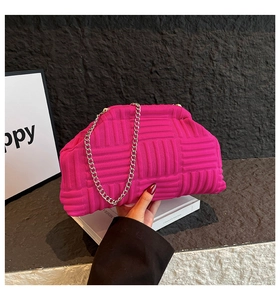 Détail du sac tricoté rose avec texture géométrique et bandoulière chaîne argentée