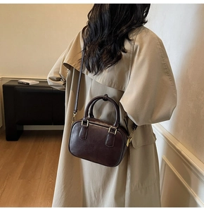 Detail view of a retro Boston style crossbody bag showing texture and golden hardware